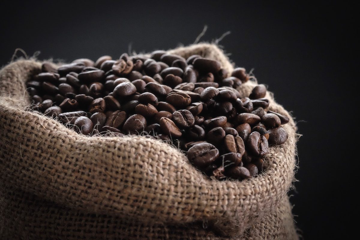 shallow focus photography of coffee beans in sack - Coffee Beans