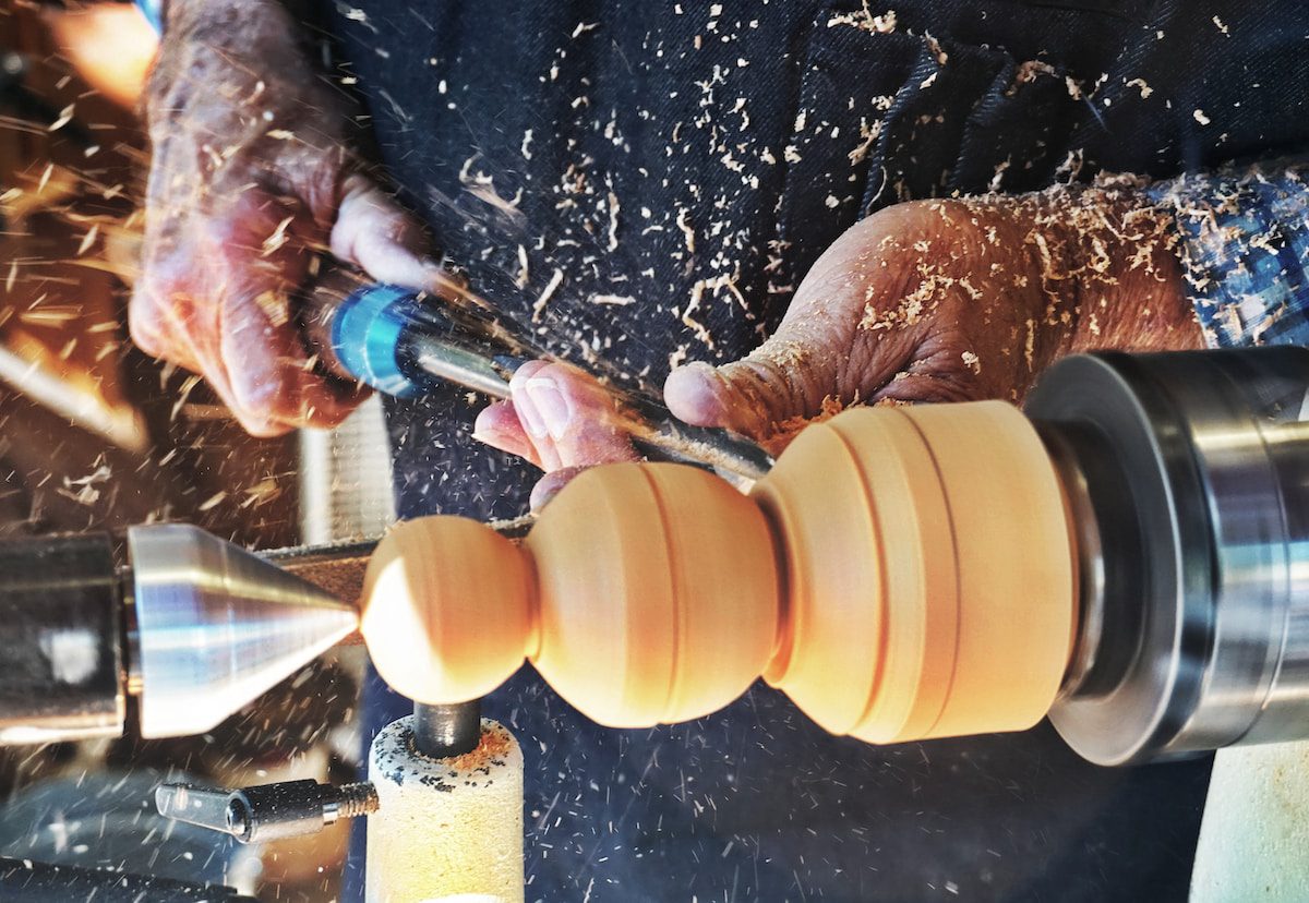 a man working on a machine in a factory - Woodworking Projects